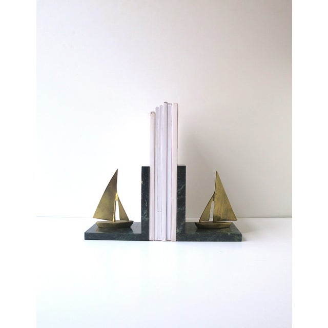A pair of dark green marble and brass sailboat bookends, a Nautical theme, circa mid to late-20th century. Bookends are a...