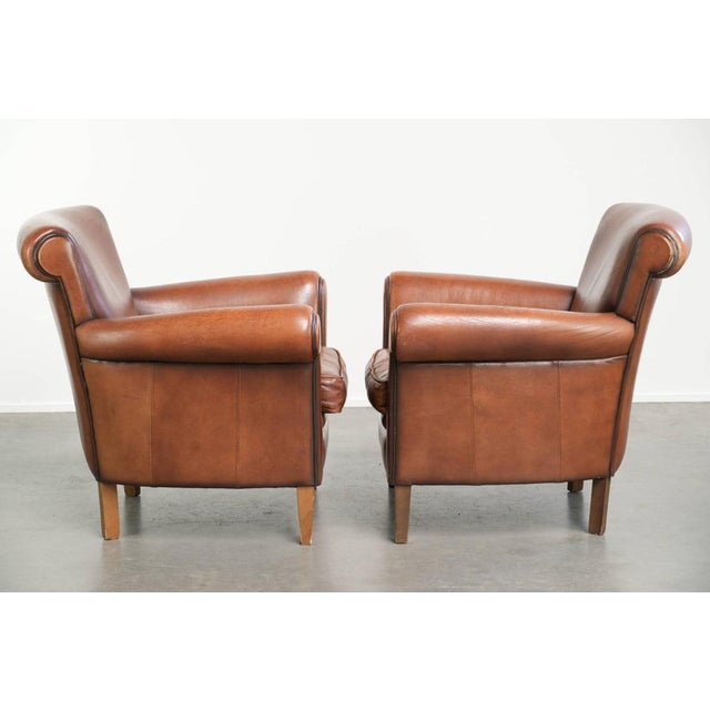 This lovely set of two comfortable sheepskin armchairs with a timeless look features a warm cognac color and a beautiful...