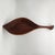 Hand-carved teak leaf-shaped bowl with sculptural stem handle and rich visible grain, mid-century modern style of Emil Milan