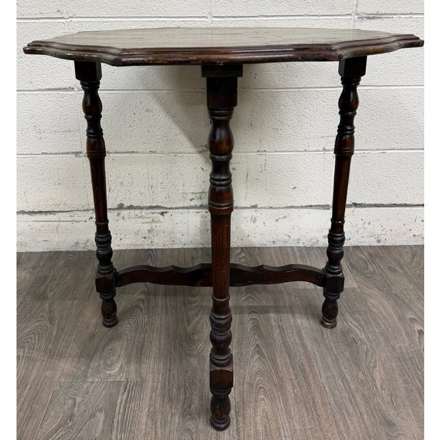 This is a gorgeous vintage Jacobean Revival oak side table with a beautifully scalloped top, turned legs, and decorative...