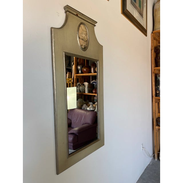 A charming 1960s vintage Italian wall mirror featuring a hand-painted wood frame with elegant neoclassical lines and a...