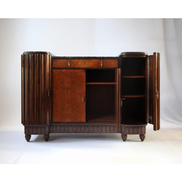 A french art deco buffet from the late 1920s, distinguished by its burl walnut veneer and green verde antico marble top....