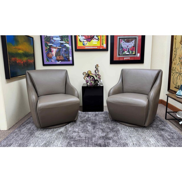 A pair of very clean contemporary Nikki leather swivel chairs by W. Schillig. The chair swivels 360 degrees and rests on...