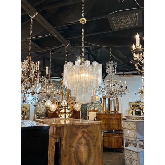 Modern Murano glass "tronchi" style chandelier in clear and polished brass. The chandelier has been professionally...