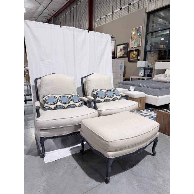 This is a refined custom seating ensemble featuring a pair of Bergère chairs with a coordinating upholstered ottoman,...