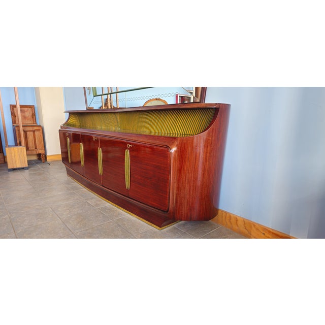 This piece of furniture, with its unique combination of fine woods, sculptural curves, and distinctive use of brass and...