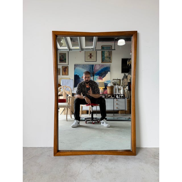 Elegant 1970’s Mid-Century Modern wall mirror featuring a clean-lined solid walnut frame with warm, rich wood tones and...