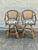 Pair of vintage rattan swivel bar stools, circa 1970s. Features woven cane backs, curved rattan arms, wrapped joint...