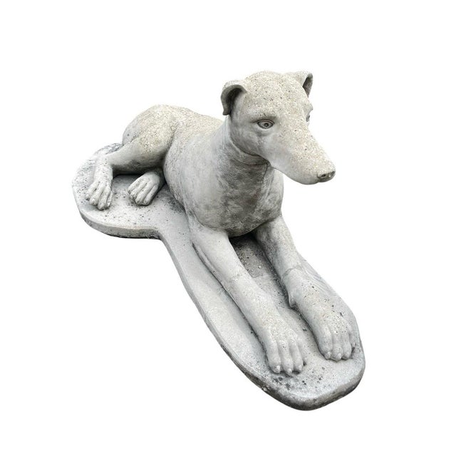 This vintage elegant garden sculpture depicts a recumbent sighthound, capturing the lean, athletic grace characteristic of...