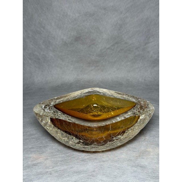 Decorative Murano glass bowl with an amber-toned central element. The clear outer glass features a textured surface...