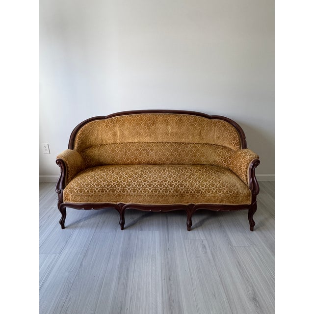 An exquisite 19th century parlor sofa featuring a gracefully carved wood frame and elegant silhouette. Upholstered in...