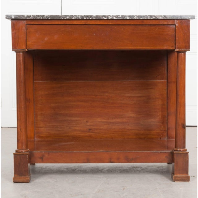 A French 19th century mahogany console in the Empire style with marble top. The gray, Saint Anne-type marble is in...