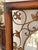 A richly decorative vintage wall mirror featuring a circular beveled mirror inset within an architectural square metal...