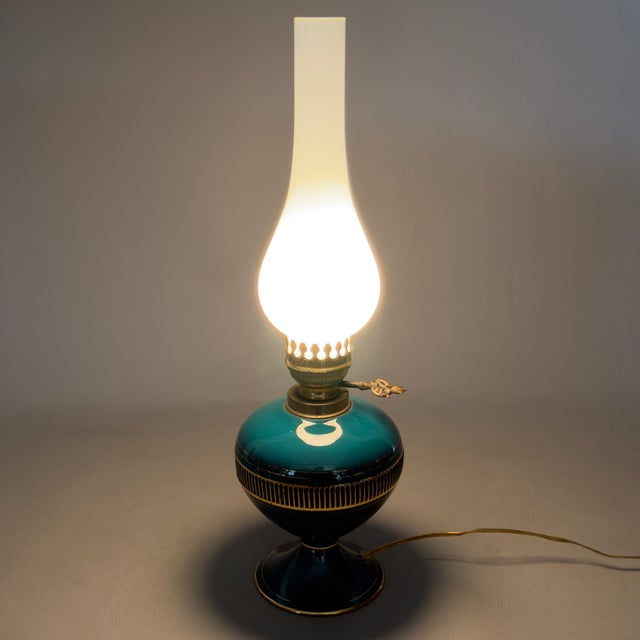Refined oil lamp-style table lamp, an elegant example of 20th-century Italian craftsmanship, crafted from enameled...