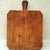 A charming, primitive-style wooden bread board featuring a hand-carved handle and unique chamfered corners. Crafted from a...