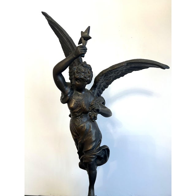 Unique Antique Bronze Statue depicting a winged woman wearing a flowing gown while holding a star over head in one hand...