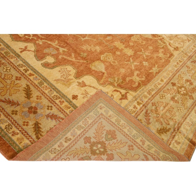 Beautiful modern Turkish hand-knotted wool rug with a copper color field. This rug has a blue-designed frame with accent...