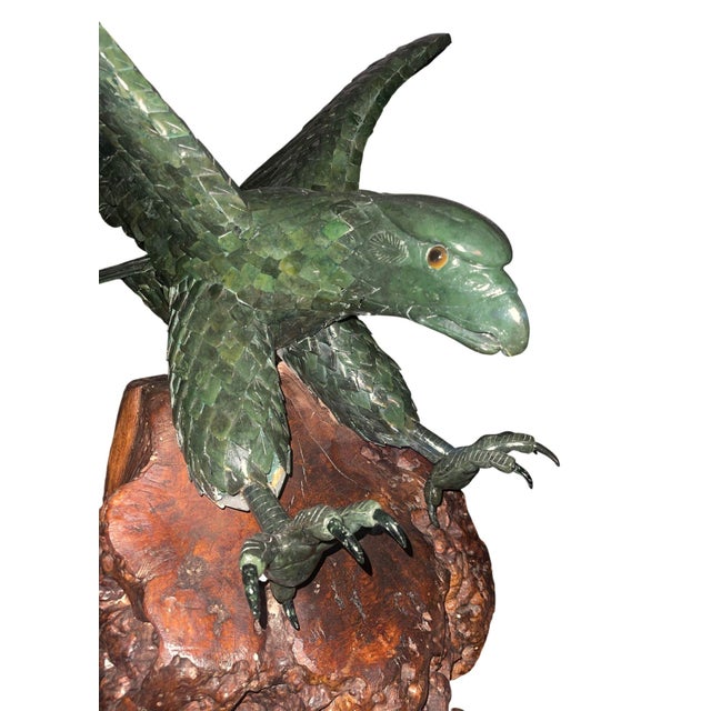 An impressive and monumental 20th century Chinese carved spinach jade sculpture depicting a powerful eagle in mid-descent,...