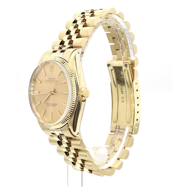 Vintage Rolex Oyster Perpetual 34mm reference 1005 champagne dial, fluted bezel, and set in 14k yellow gold. Fitted with a...