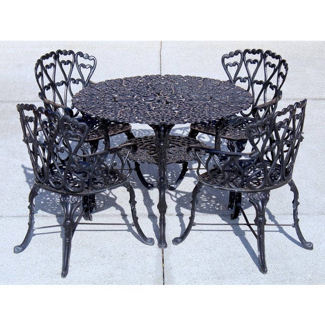 Elevate your outdoor space with this exceptional vintage cast aluminum patio dining set, evocative of mid-century garden...