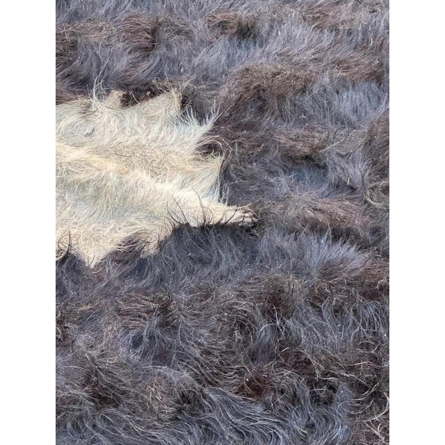 Vintage Turkish tribal Kilim with hair at a side, with a simple and tribal design and a dark brown and white colours, with...