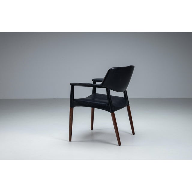 Large mid-century armchair in solid rosewood and black leather upholstery, produced by Willy Beck in Copenhagen in the...