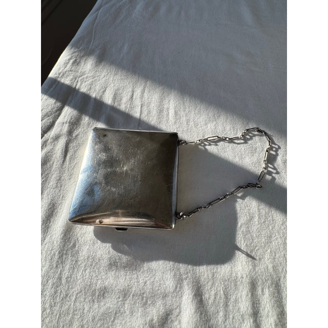 An exquisite antique sterling silver compact with a hinged lid, featuring an interior mirror and accents of 14K gold. The...