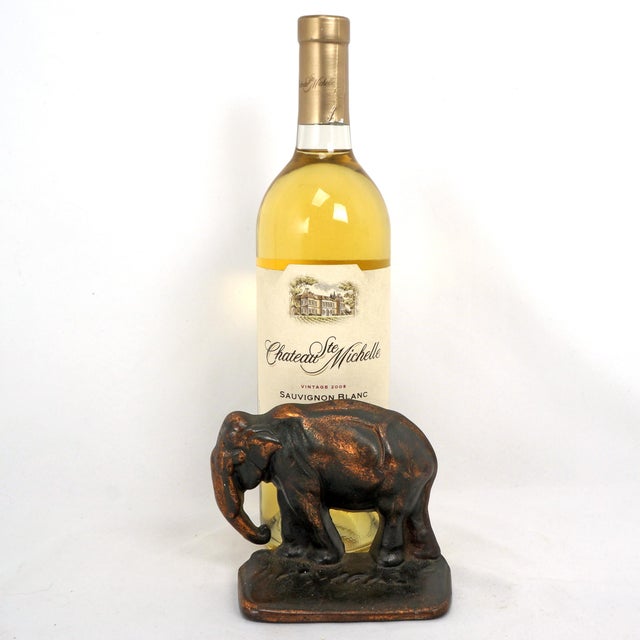 A heavy and deeply case antique cast iron bookend of a walking elephant. It has been given a rich copper patina. The...