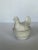 Cute little white ceramic hen sitting on a basket dish. Remove hen top and store all of your nicknacks in the basket....