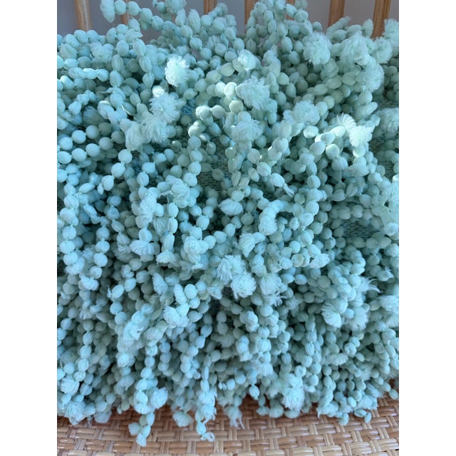 Whimsical and wonderfully textured decorative throw pillow in a soft mint green tone featuring cascading pom pom fringe...