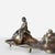 Elongated wave-form base with classical draped figure reclining against rolling sea at one end. Hinged inkwell compartment...
