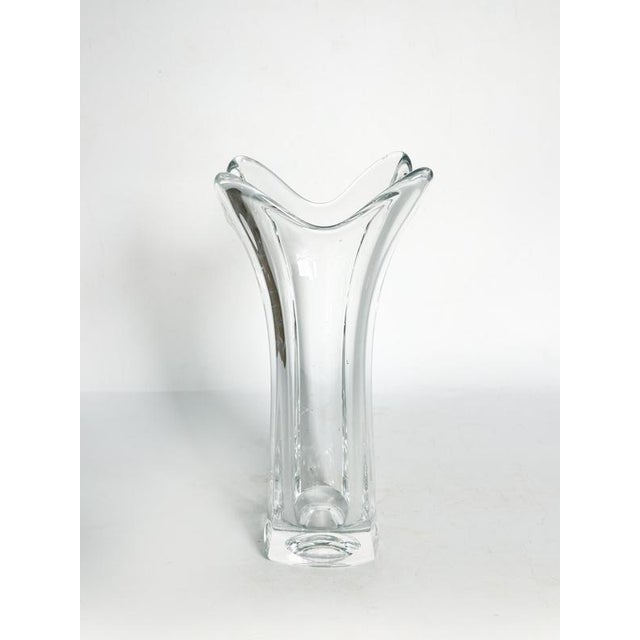 Crystal vase, France, 1970s, remarkable for its slender, organic shape with fluid lines. Its wide, almost corolla-like...