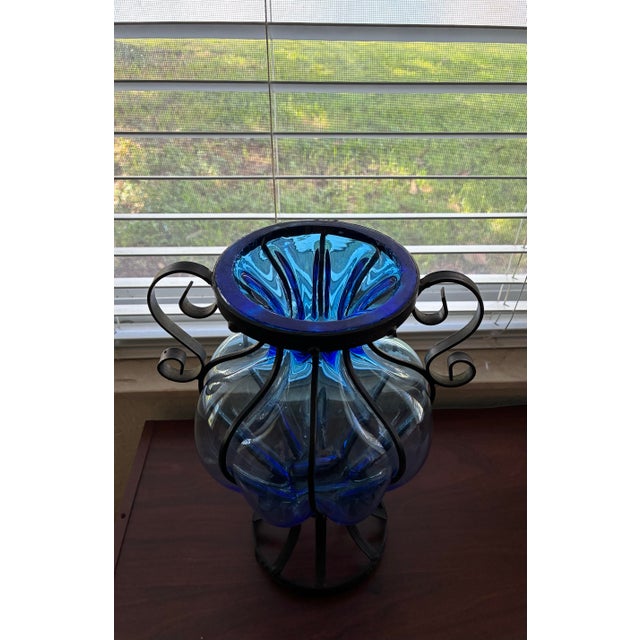 Add a stunning touch of vintage elegance to your home with this beautiful hand-blown cobalt blue glass caged vase. The...