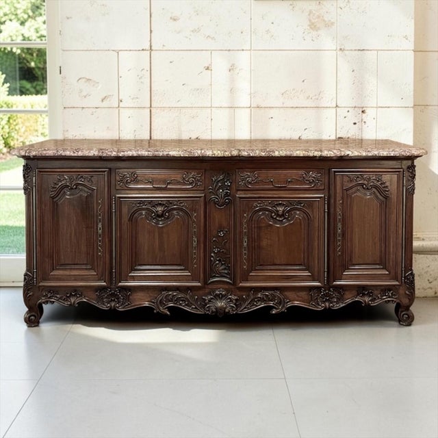 Grand in scale and beautifully proportioned, this antique French walnut buffet has exceptional presence, with a broad...