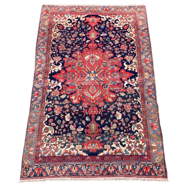 A beautiful antique Malayer rug, woven circa 1900. The design features a large tomato red medallion on an indigo field and...
