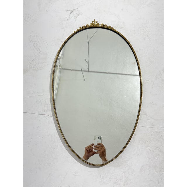 Oval brass wall mirror, Made in Italy, 1950s Mirror intact, small signs of aging on the brass that make the mirror even...