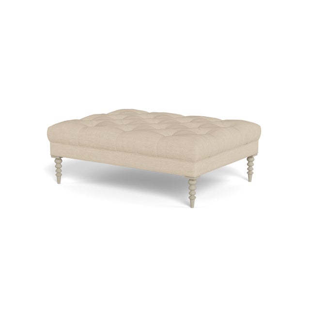 A large cocktail ottoman, with beautiful tufting set atop a trim upholstered box, with wonderfully turned legs. Legs...