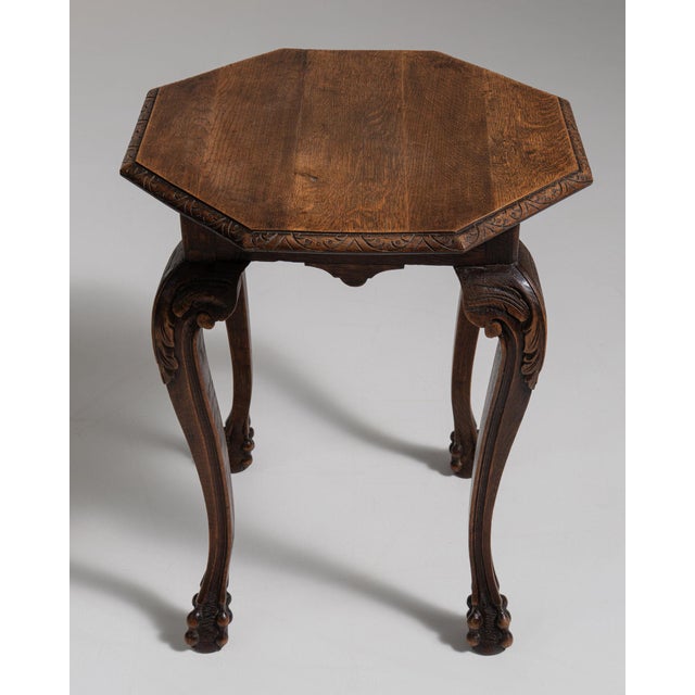 Carved octagonal side table in Rich Walnut Brown. Its rich walnut brown finish sets off scrolled cabriole legs, shaped...