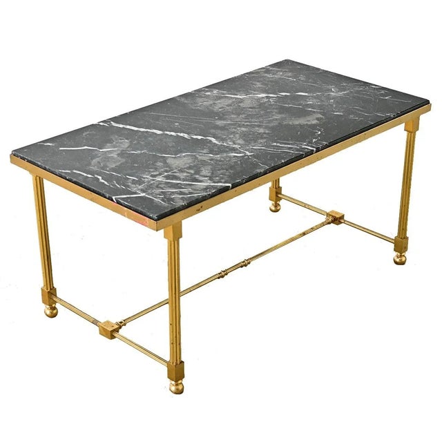 Dimensions: 16 ½” H x 34 ⅜” W x 17 ⅞” D A vintage midcentury French brass and marble coffee/cocktail table in the style of...