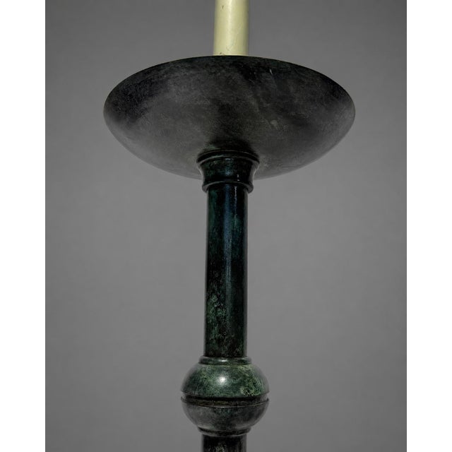 A pair of bronzed metal candlestick-form table lamps in the antique taste, each with a tall columnar shaft, dished...