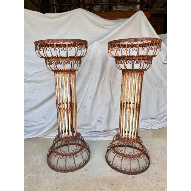 This Pair of Mid 20th Century Plant Stands were crafted from iron in the mid 1900's. Each of the plant stands feature a...