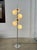 1970s floor lamp with a chromed metal frame, six opal glass globes, and a foot switch. Two of the globes are glossy opal...