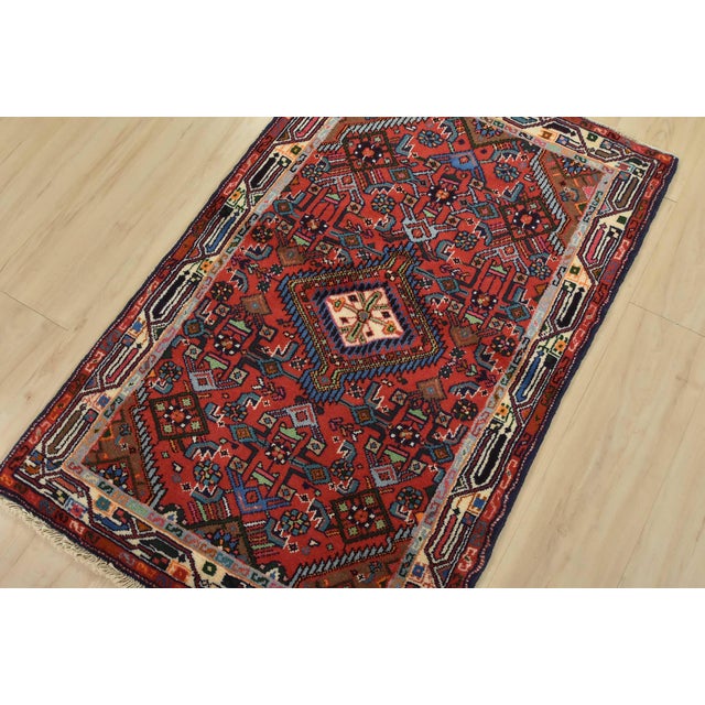 An authentic vintage tribal Hamedan rug hand-knotted with fine wool and natural dyes. This nomadic rug features a central...