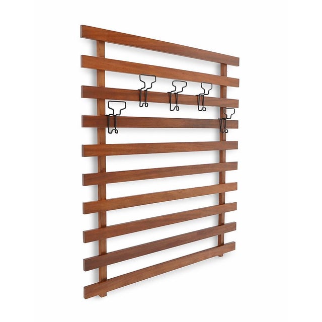 Italian manufacturing wall bend produced in the 1960s. Structure made up of solid wood lists. Black painted metal hangers...