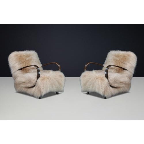 A rare pair of iconic 1940s halabala lounge chairs, newly upholstered in luxurious icelandic sheepskin, combining...