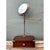 This vintage vanity mirror exemplifies the practical elegance of campaign-style furniture, combining a rich mahogany-toned...
