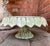 Vintage MCM Italian art pottery cake stand featuring green majolica turned-down leaf detail around the platter and a faux...