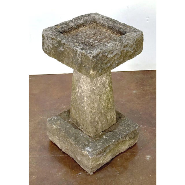A fine English garden bird bath of cut and chiseled Purbeck stone, from the late 19th century, featuring a square top with...