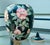 Gorgeous hand-painted porcelain temple jar with lid. The backdrop is a deep green, almost black shade. The perfect...