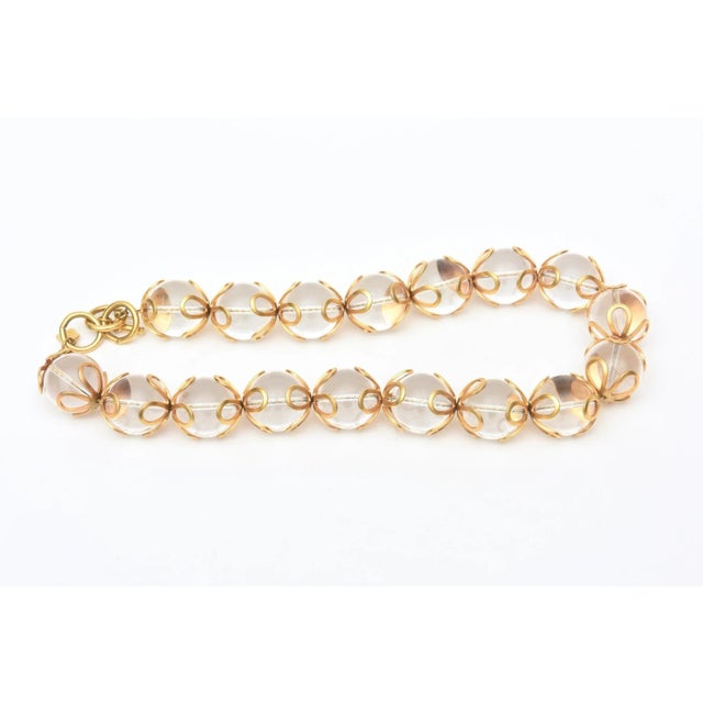 This is part of Chairish’s Costume Jewelry assortment. This great original vintage Anne Klein chunky lucite ball and gold...